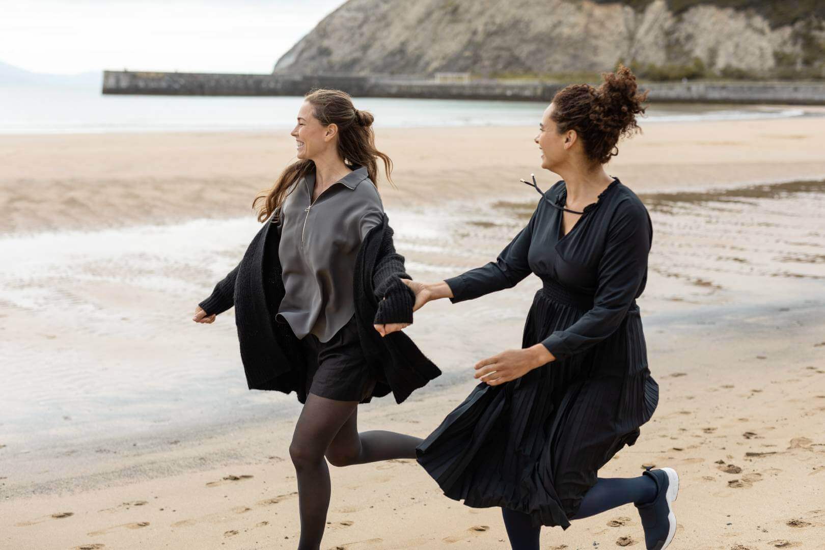 Twee vrouwen lopen op het strand. Beiden dragen VenoTrain micro compressiekousen van Bauerfeind.