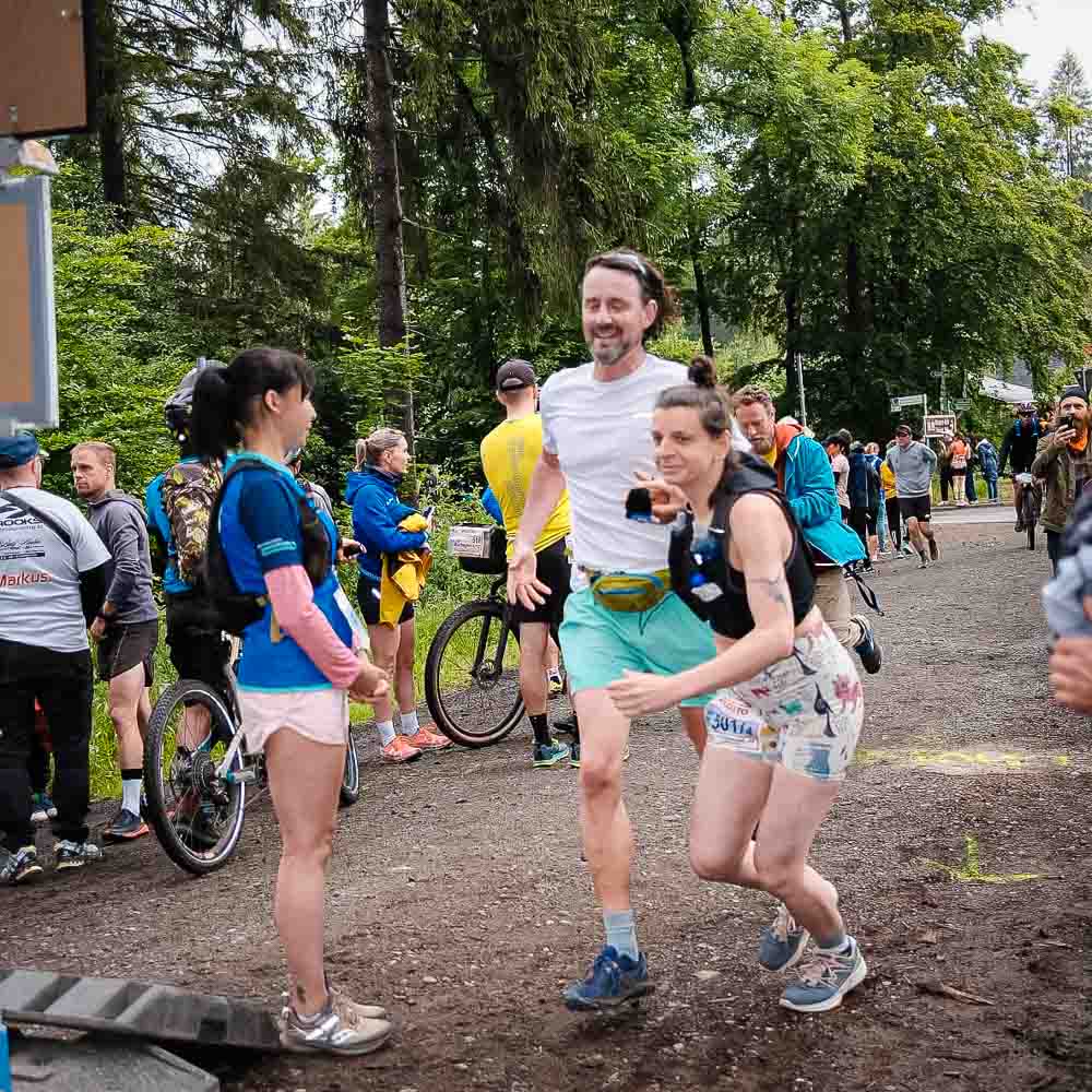 Een man en een vrouw lopen samen terwijl verschillende mensen op fietsen op de achtergrond staan