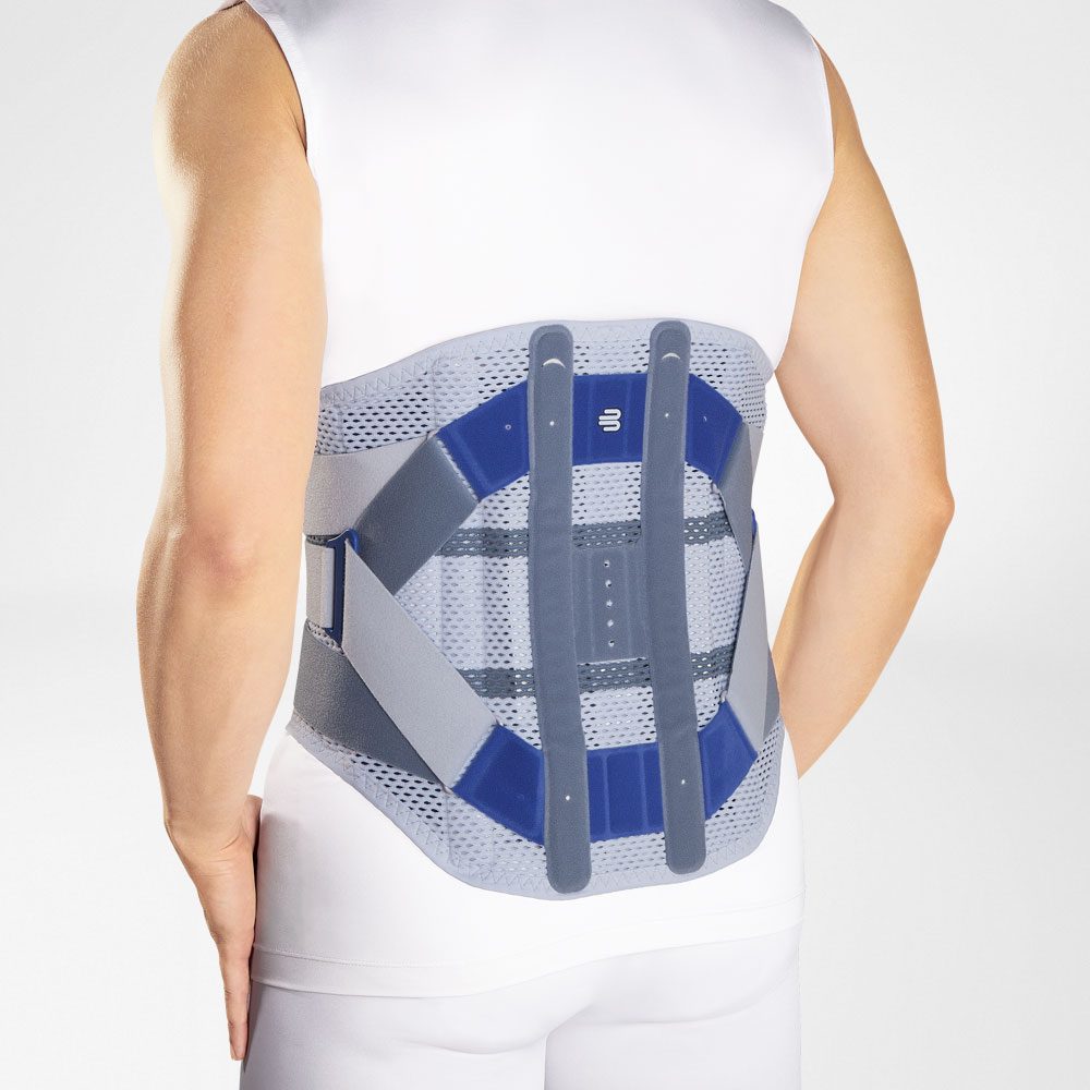 Rugaanzicht van een persoon met een grijs-blauwe lendenbrace over een wit shirt.