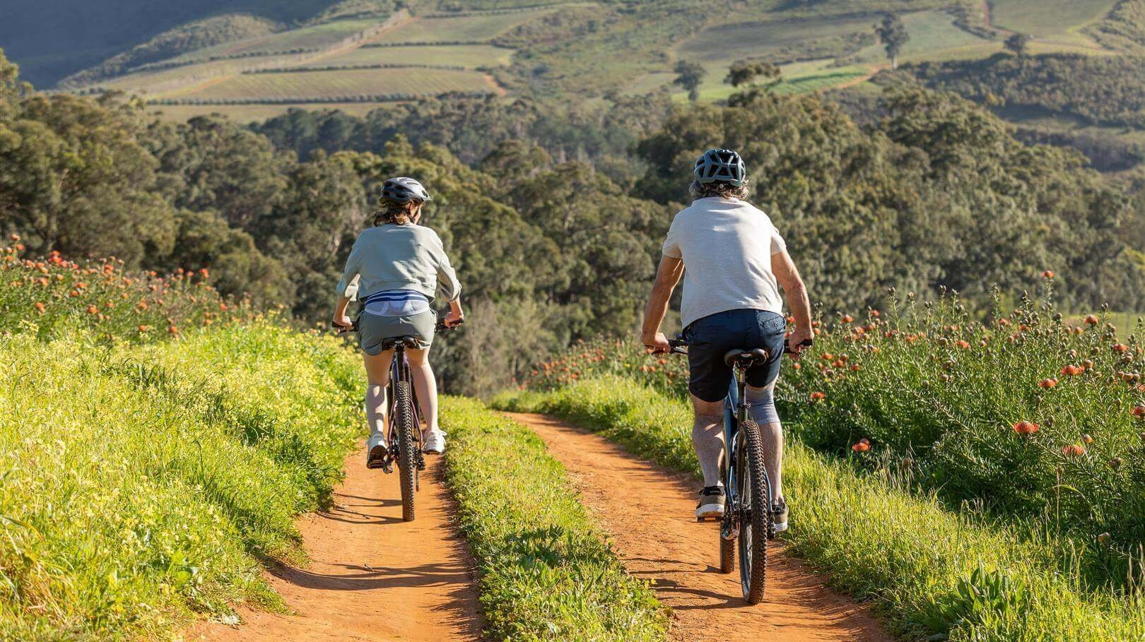 Afgebeeld is een ouder stel tijdens een fietstocht. De vrouw draagt een LumboTrain rugbandage van Bauerfeind om lage rugpijn te voorkomen terwijl ze onderweg zijn.