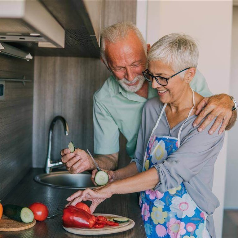 De afbeelding toont een man en een vrouw die samen koken. We leggen uit waarom gezonde voeding bij artrose belangrijk is en hoe die eruit zou moeten zien.