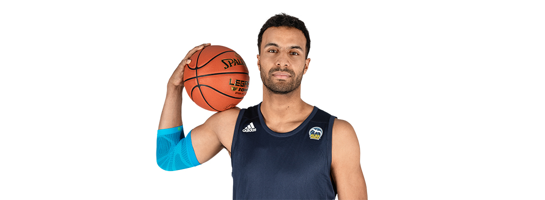 Man met basketbal draagt ​​een sportleeve voor de elleboog