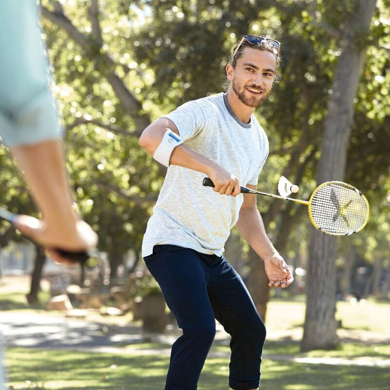 Man draagt Bauerfeind EpiPoint elleboogband tijdens badminton voor stabiele armsteun.