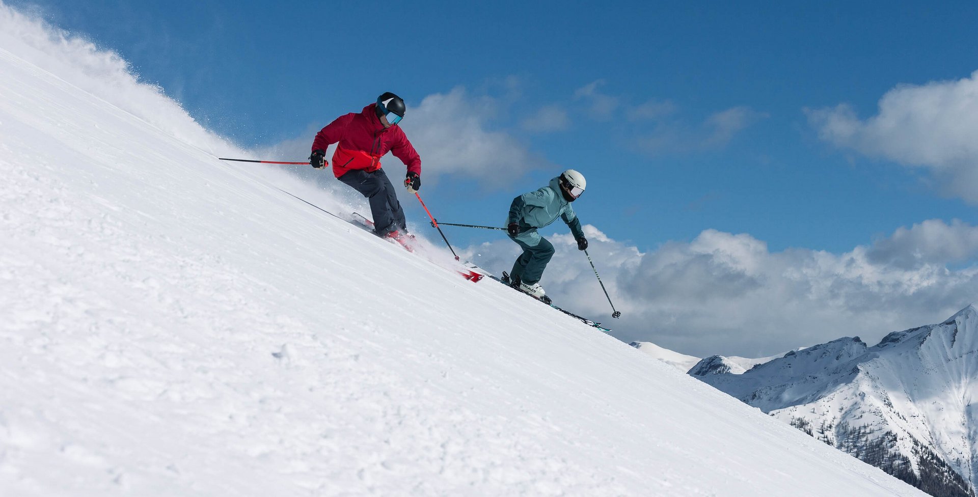 Te zien zijn twee skiërs die net aan een afdaling bezig zijn.