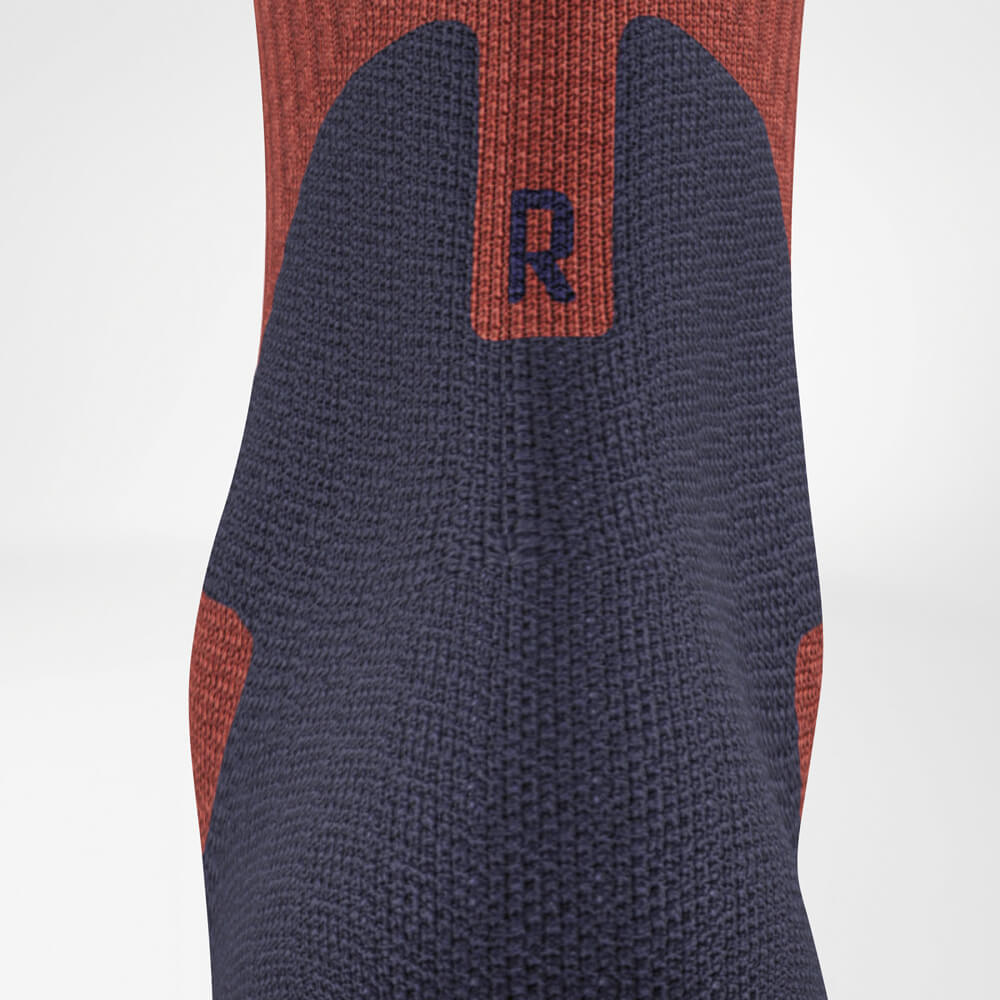 Close-up van de Merino Outdoor Socks van achteren. Het naadloze ontwerp en de gerichte achillespeespolstering bieden comfort en bescherming bij langdurig gebruik buitenshuis.