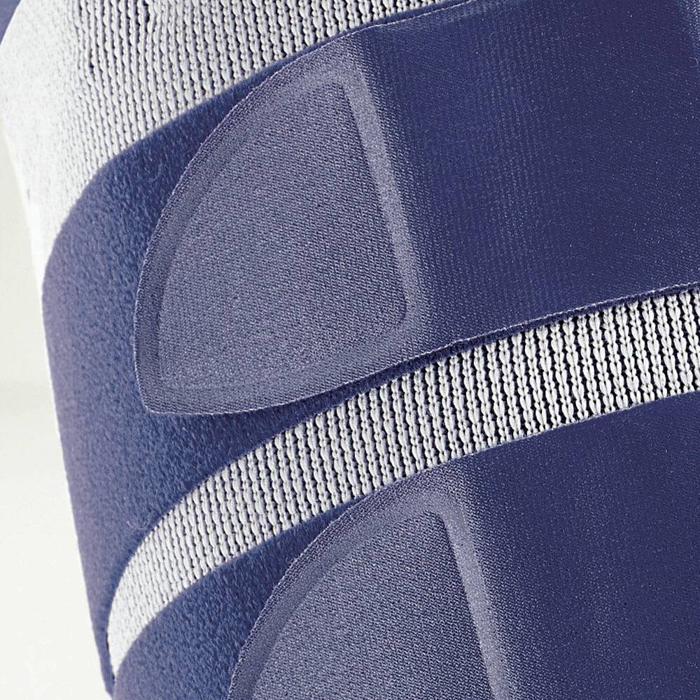 Close-up van blauw elastisch textiel met grijze gebreide banen en overlappende verstevigingsstukken.