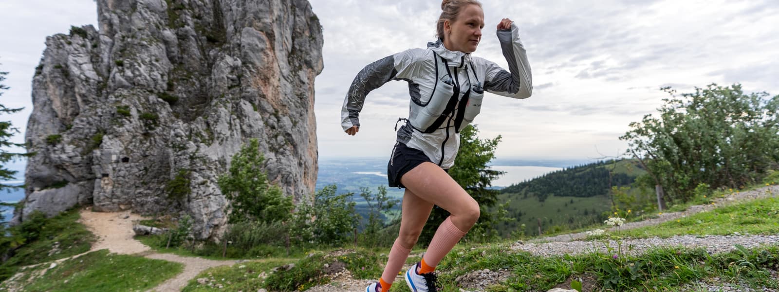 Hahner Zwilling rent een berg op en draagt ​​de trailrunsokken in de kleuren perzik
