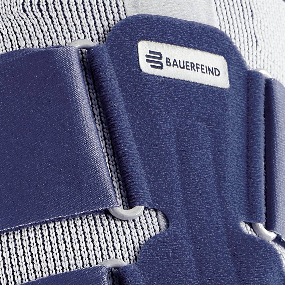 Close-up van een blauw-grijze orthopedische bandage met klittenband en zichtbaar label 'BAUERFEIND'.