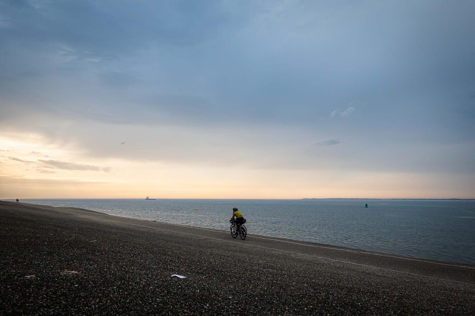 Twee deelnemers aan de Race om Nederland fietsen de avondzon tegemoet.