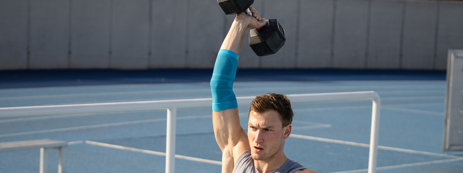 Thoms Röhler houdt een gewicht omhoog en stabiliseert zijn arm met behulp van een elleboogband