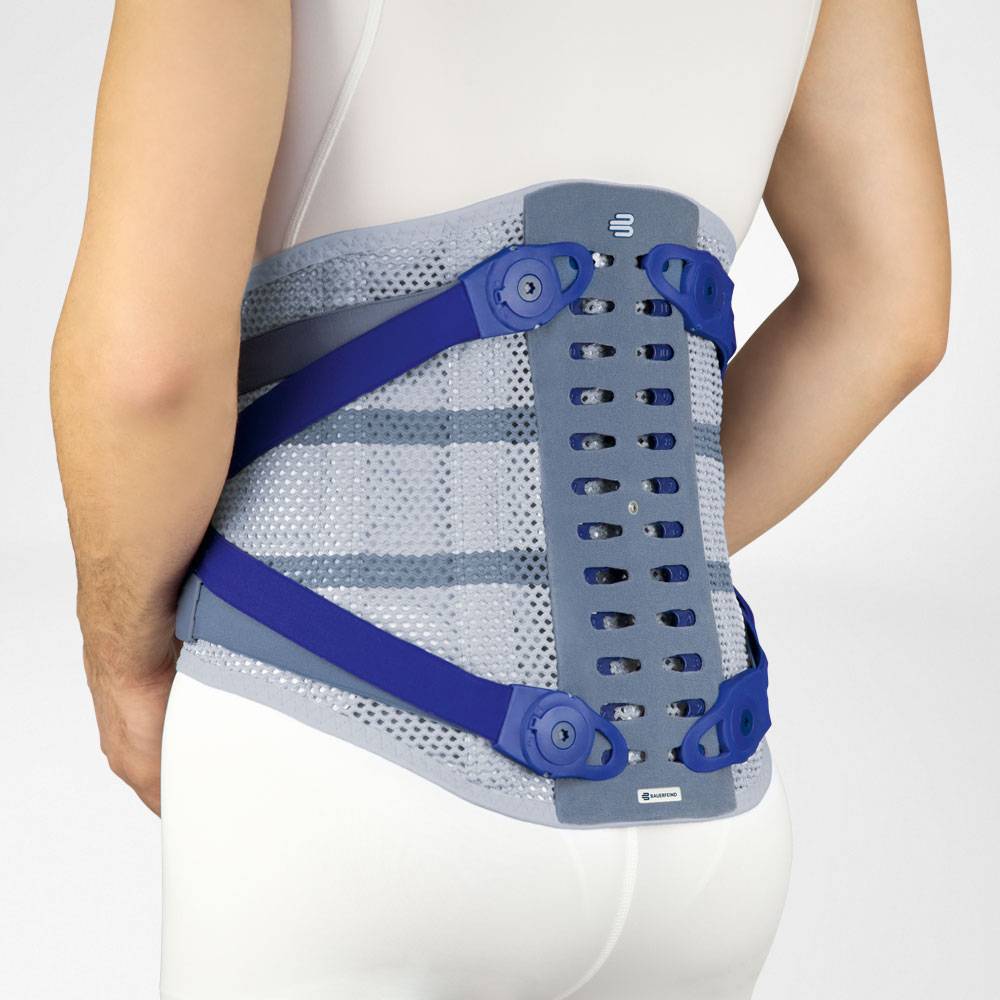 Persoon draagt een grijze rugbrace met blauwe verstelbanden rond de onderrug.