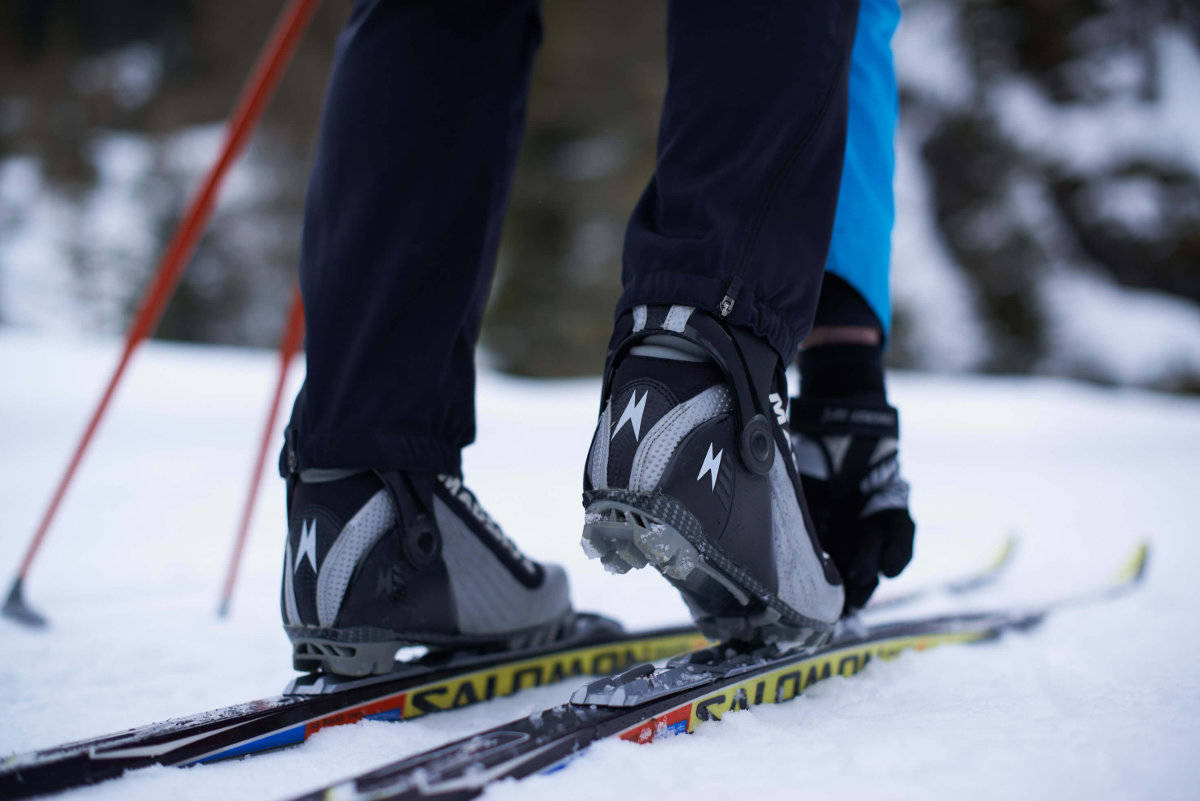 Een langlauf skiër knogelt zijn schoenen aan de ski's close-up