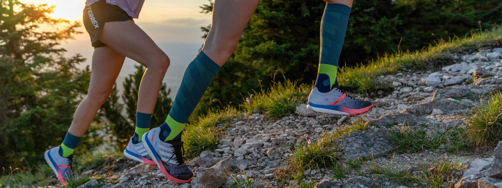 Lopers rennen een berg op en dragen trail run sokken