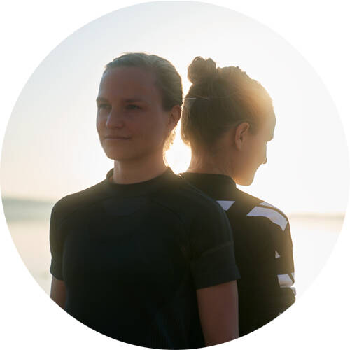 Long -afstandlopers Anna en Lisa staan ​​terug op terug voor een portret van ronde beeldsectie