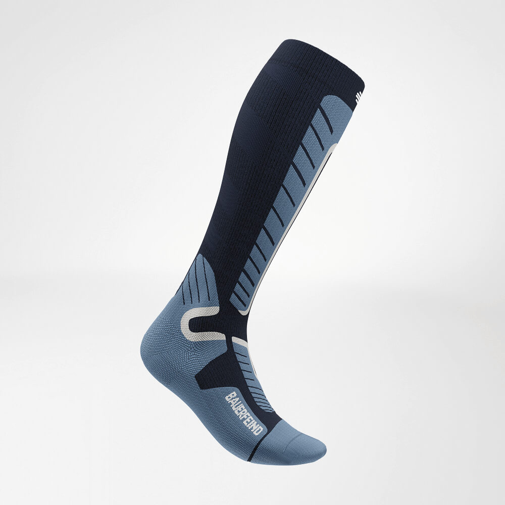 Zijaanzicht van een blauwe ski-compressiesok tot aan de knie, met versterkt breipatroon voor maximale ondersteuning en comfort tijdens het skiën.