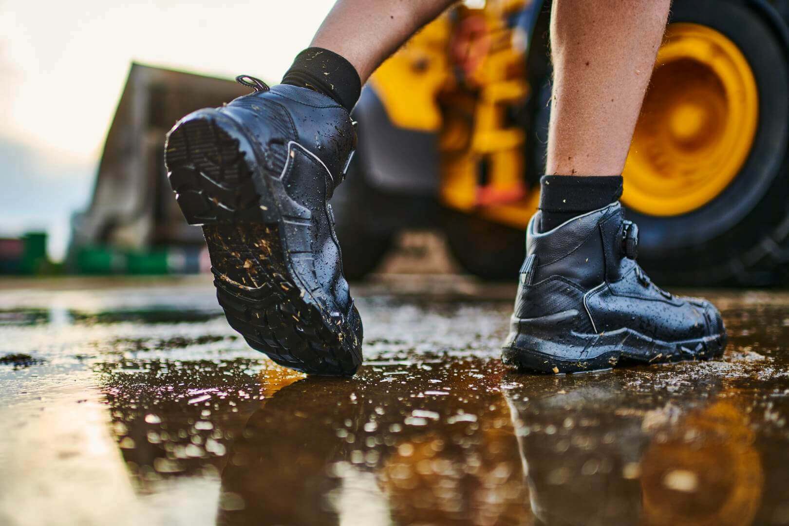 Een persoon loopt door een plas met schoenen waarin inlegzolen zitten. Deze inlegzolen zijn de ergopad work:h+ van Bauerfeind.