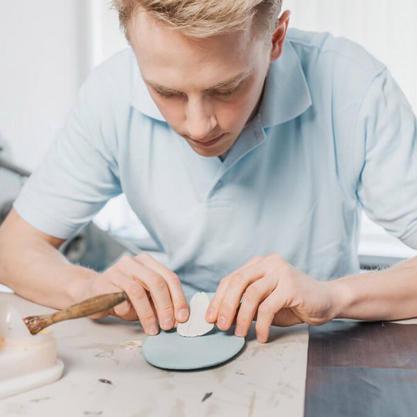 Een jonge man repareert een inlegzool. Bauerfeind biedt diverse diensten voor medische vakhandelaren en orthopedisch (schoen)technici.
