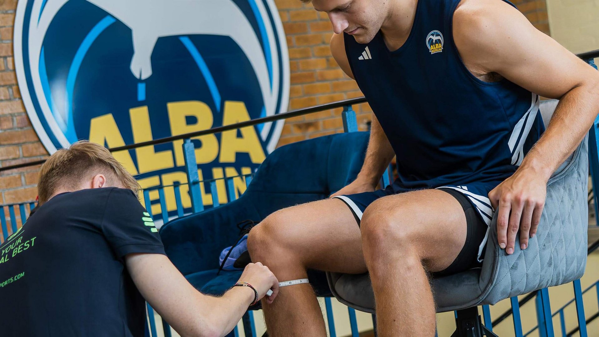 Opmeten van een atleet van Alba Berlin door een medewerker van Bauerfeind Sports