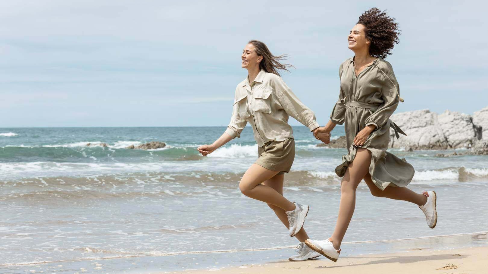 Twee vrouwen rennen langs een strand. Beiden dragen VenoTrain soft compressiekousen van Bauerfeind.