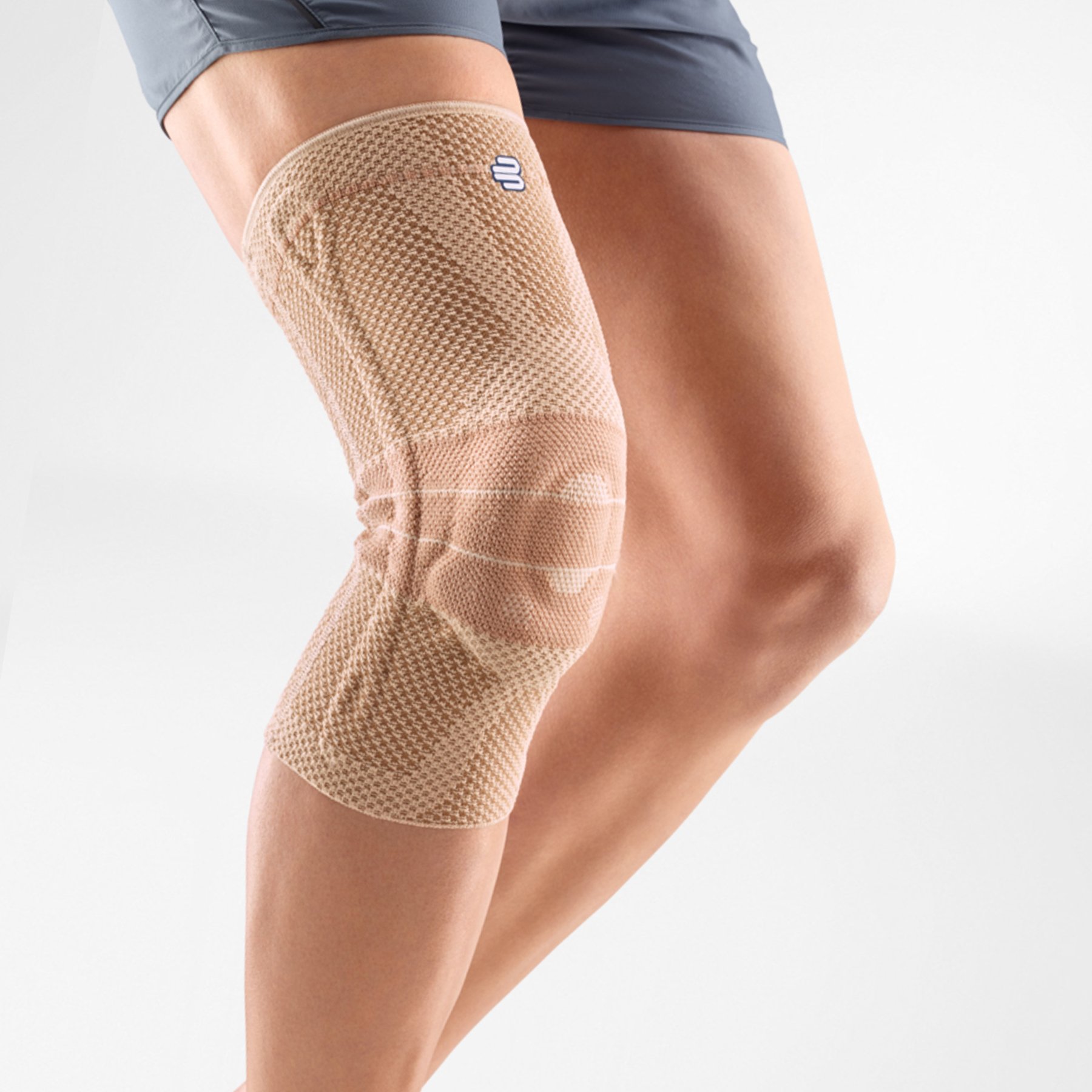 Beige Bauerfeind GenuTrain kniebrace voor stabiele ondersteuning en compressie.