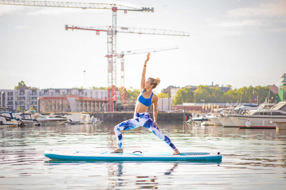 Vrouw maakt yoga op het water: op haar handen op haar handen staan