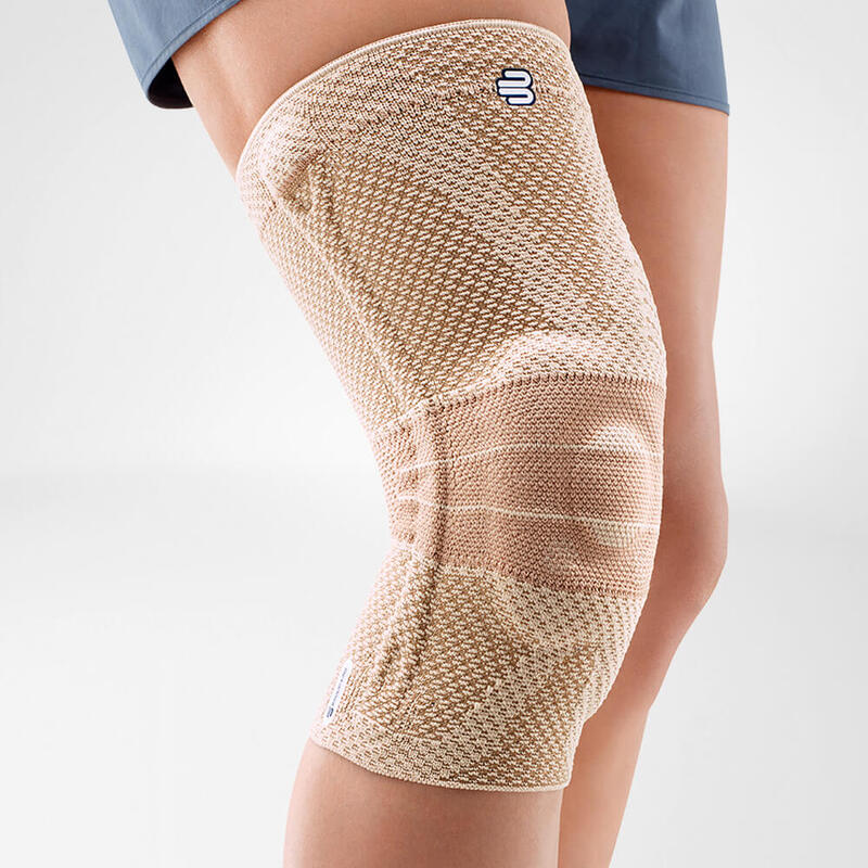 Close-up van beige Bauerfeind GenuTrain A3 artrose kniebrace voor kniesteun.