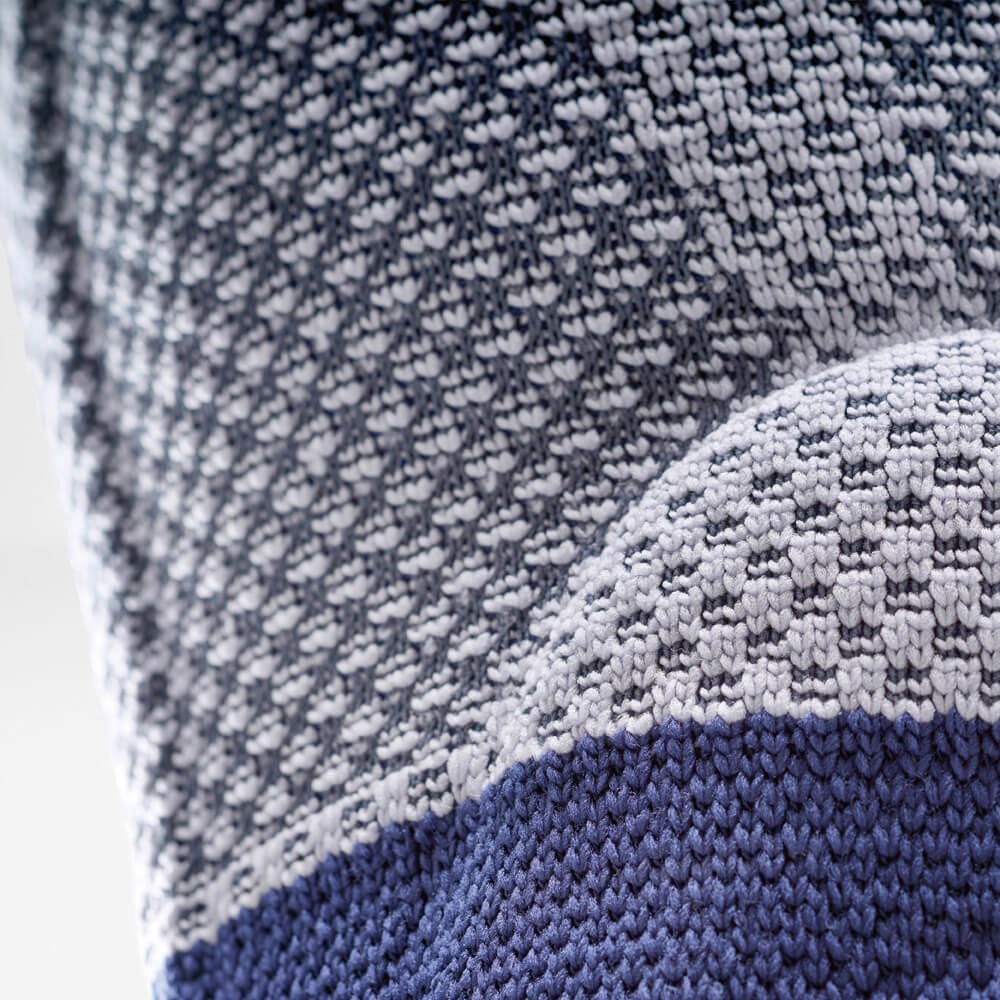 Macro van grijs-blauw kniebrace-breisel met ademende compressietextuur.