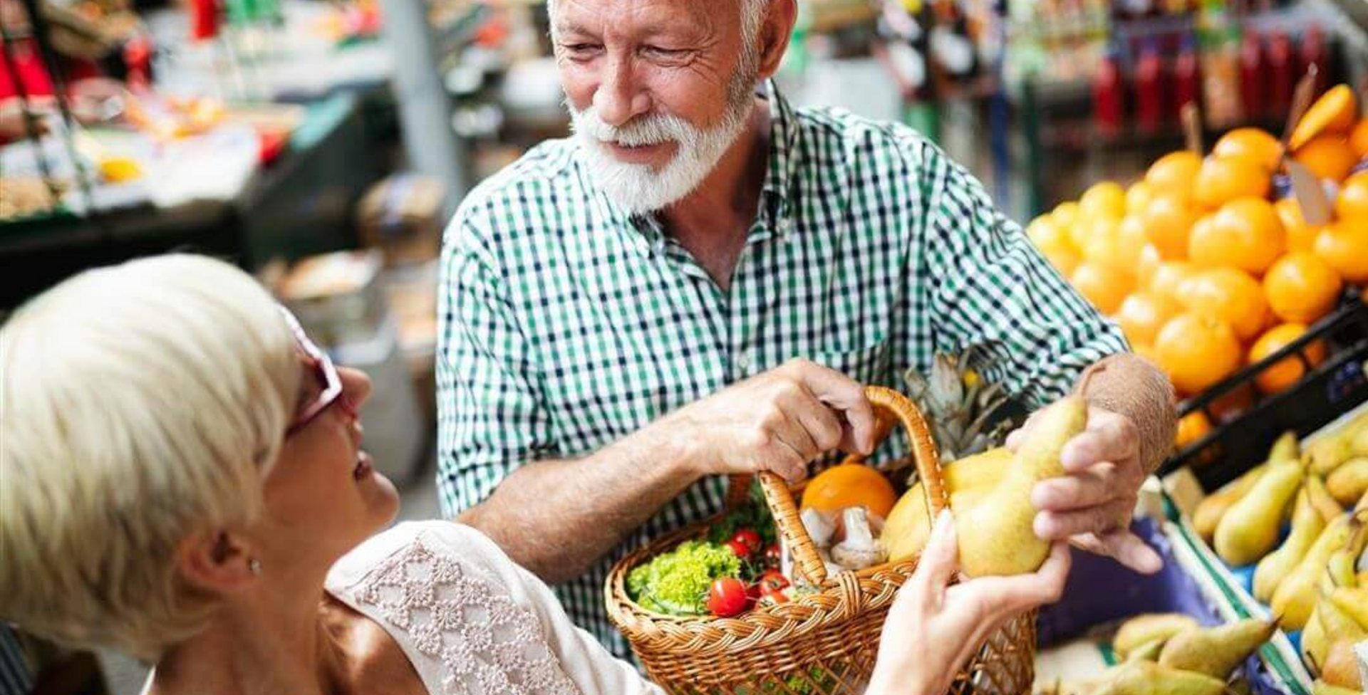 Op de foto staan een man en een vrouw bij een fruitkraam op de markt. Ze willen met gezonde voeding hun artrose te lijf gaan.