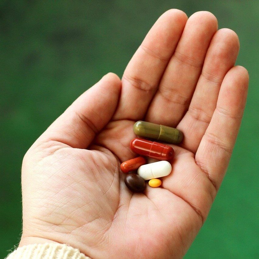 Het beeld toont een uitgestrekte hand met daarin diverse medicijnen. Kom meer te weten over werkzame middelen tegen artrose.