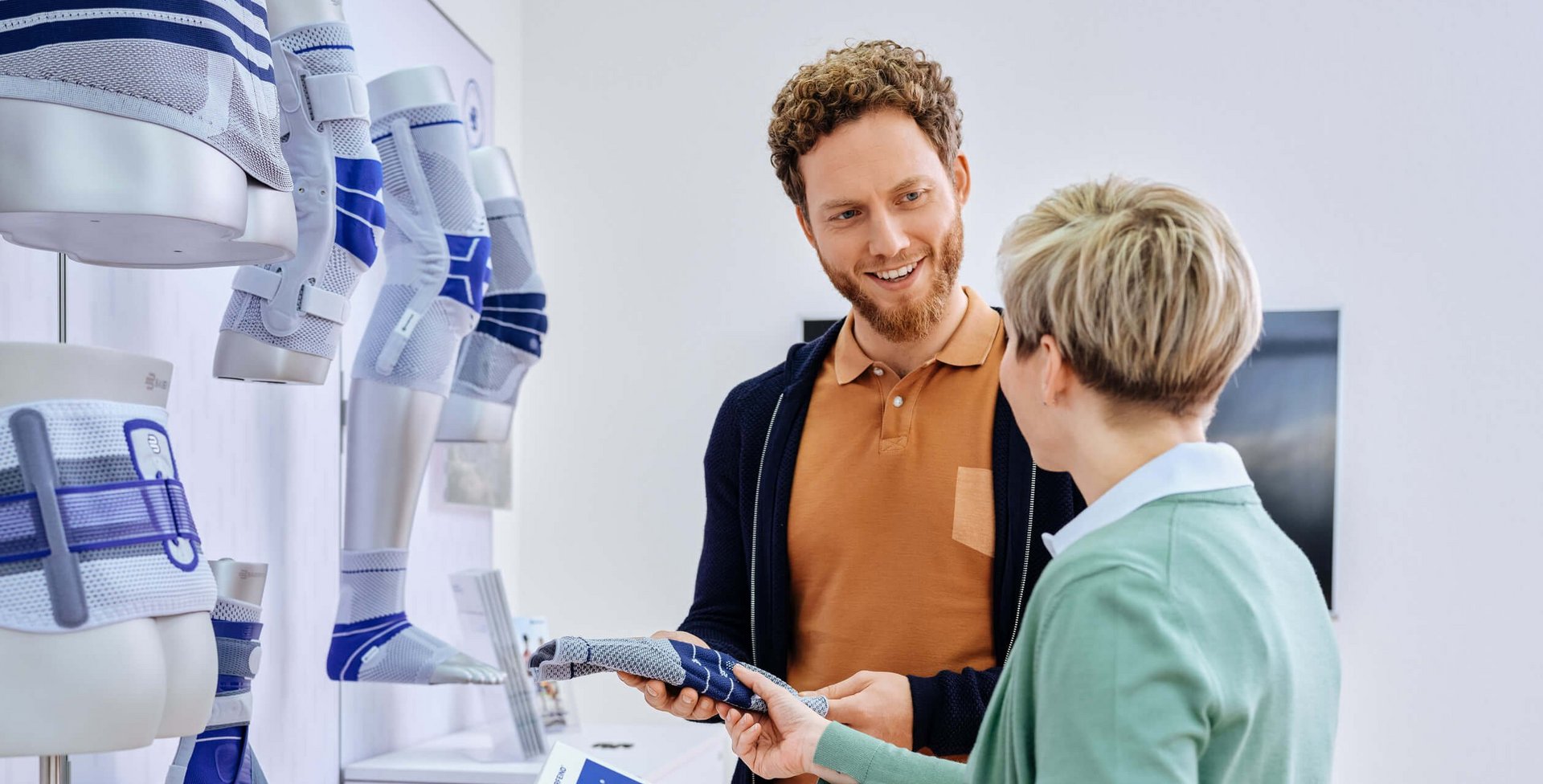 Te zien zijn een man en een vrouw in een adviesgesprek in de medische speciaalzaak over de braces van Bauerfeind.