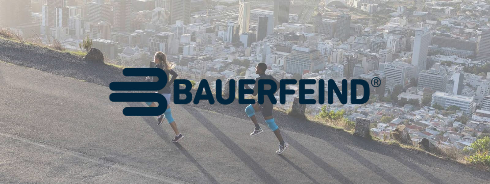 Bauer vijandelijke belettering op een foto waar twee lopers op een berg over de stad lopen
