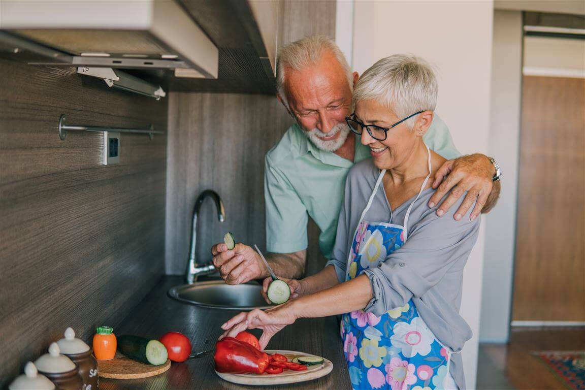 De foto toont een man en een vrouw die samen koken. We leggen uit waarom een gezonde voeding bij artrose belangrijk is en hoe die eruit zou moeten zien.