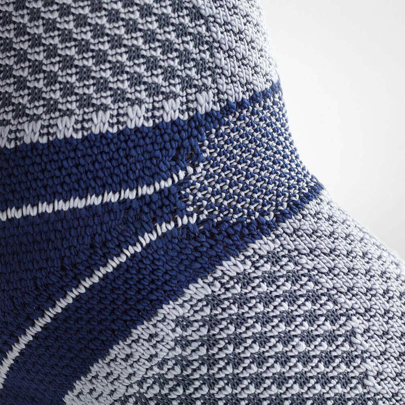 Close-up van persoon met blauwe MalleoTrain compressie-enkelbrace voor steun en mobiliteit.