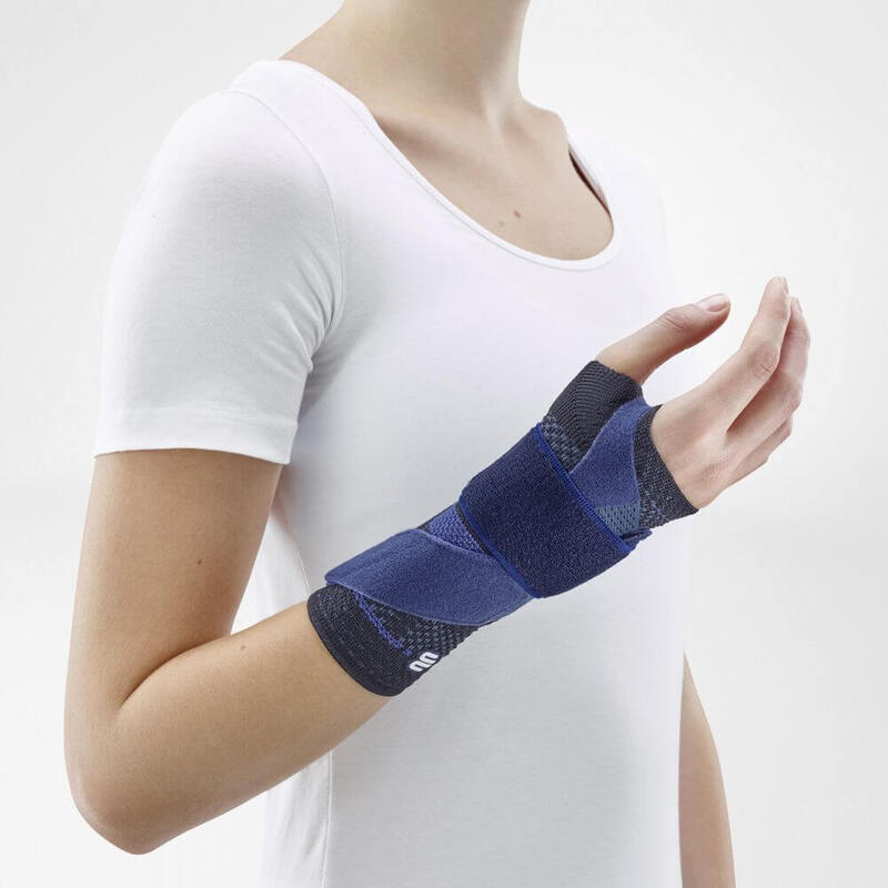 Vrouw draagt zwarte Bauerfeind ManuTrain polsbrace voor comfortabele polsondersteuning.