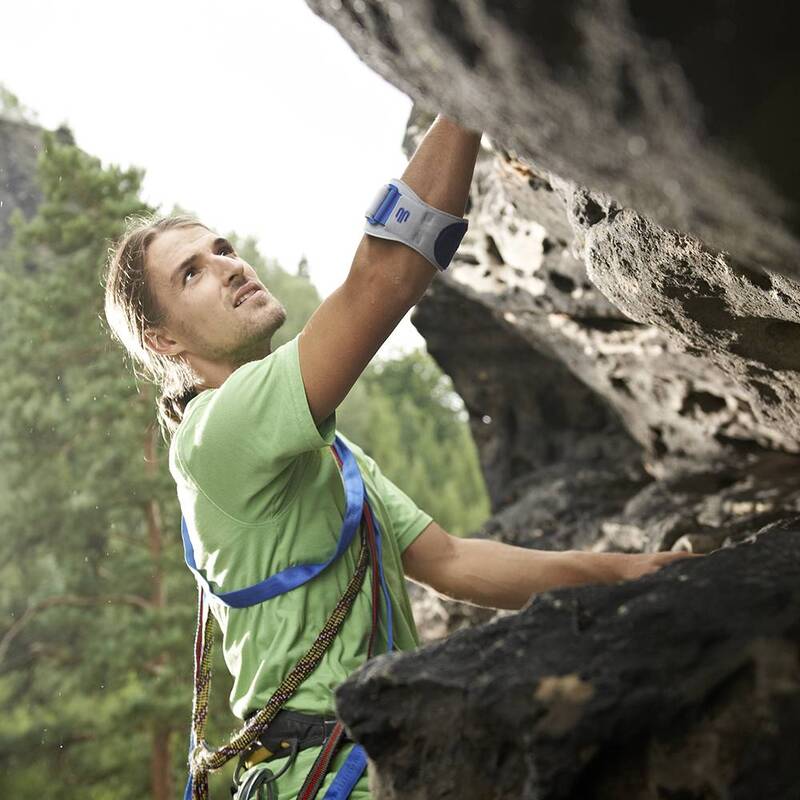 Man draagt Bauerfeind EpiPoint elleboogband tijdens bergbeklimmen voor gerichte ondersteuning.