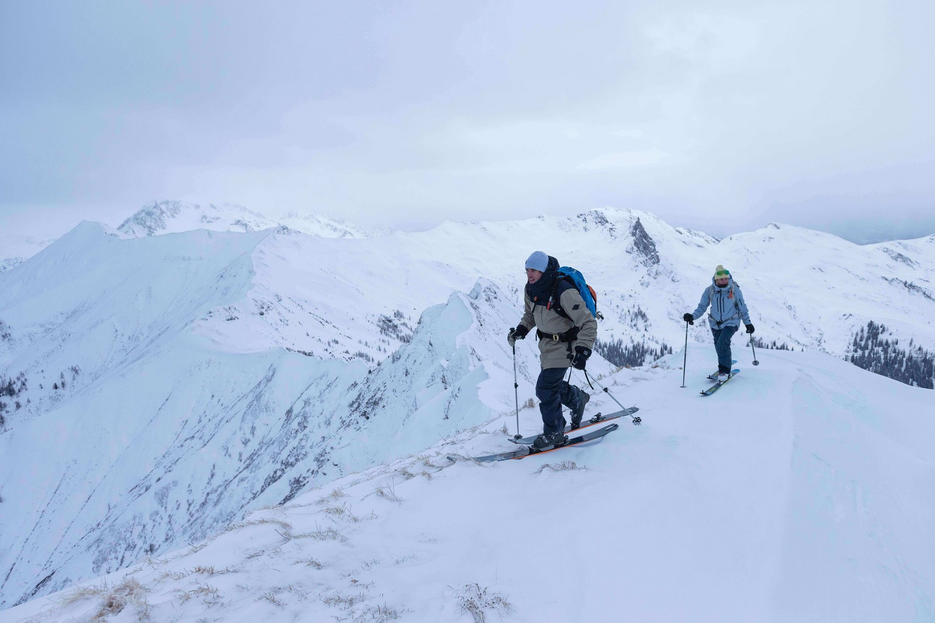 Het beeld toont twee personen die in de bergen een skitourtocht maken.