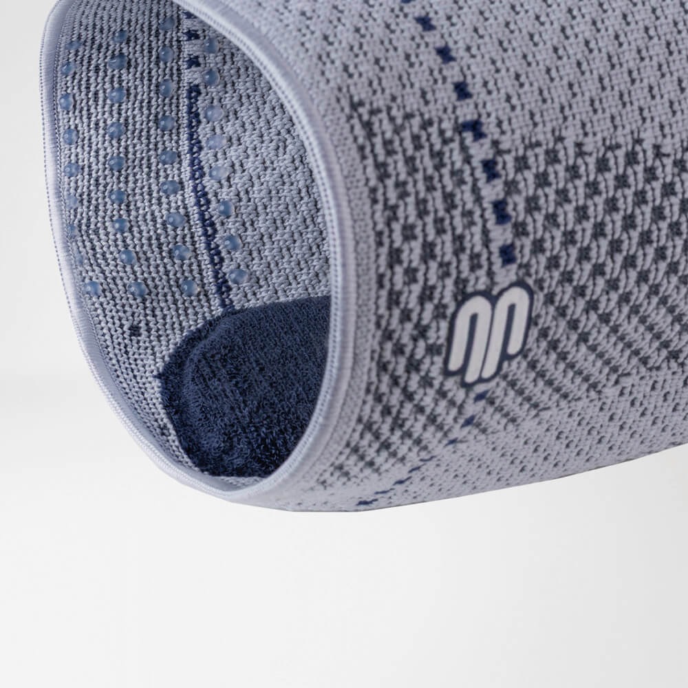 Close-up van zwarte en blauwe verstelbare kniebrace voor gerichte ondersteuning en stabiliteit.
