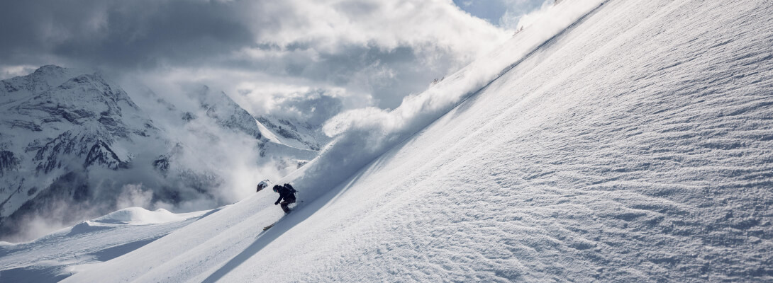 Skiër op een steile piste op downhill ski's